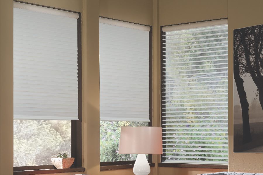 Opaque motorized window shades in Las Vegas keep hot UV rays out of your home. Gray motorized sheer shades on corner windows next to gray furniture