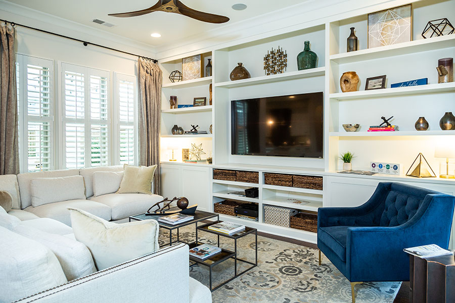 White Polywood shutters on windows in a large living space with built-in shelves.