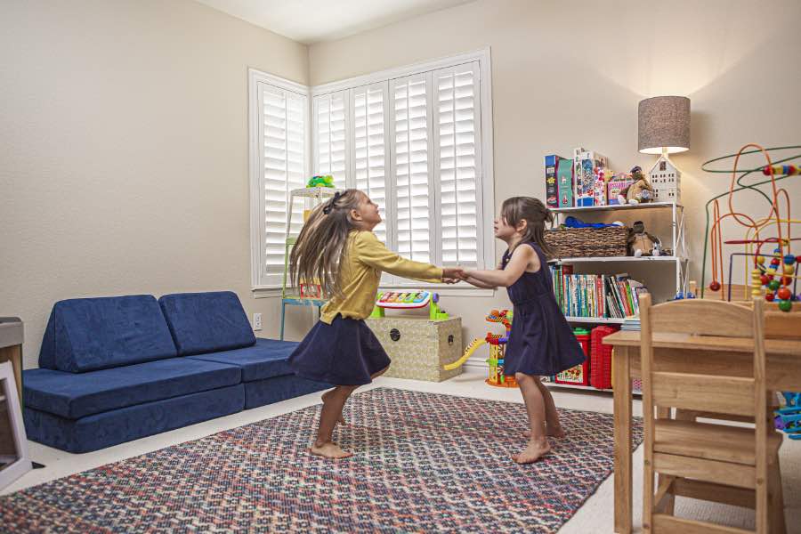 Choose Polywood shutters for durable, kid-friendly great room window treatments in Las Vegas. Polywood shutters on multiple windows in a sitting area