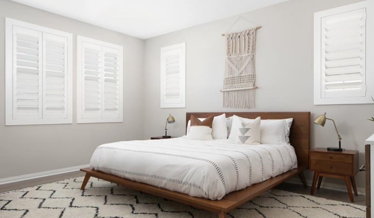 Open shutter louvers will help any Las Vegas room feel larger. Plantation shutters in a model home bedroom.