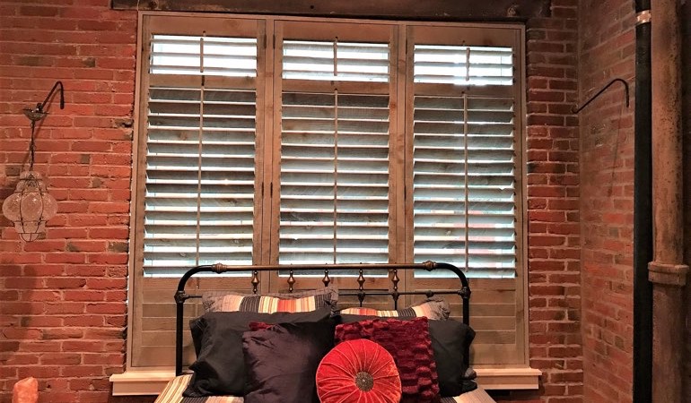 Reclaimed wood shutters give a natural touch to your minimalist spaces. Reclaimed wood shutters surrounded by brick wall.