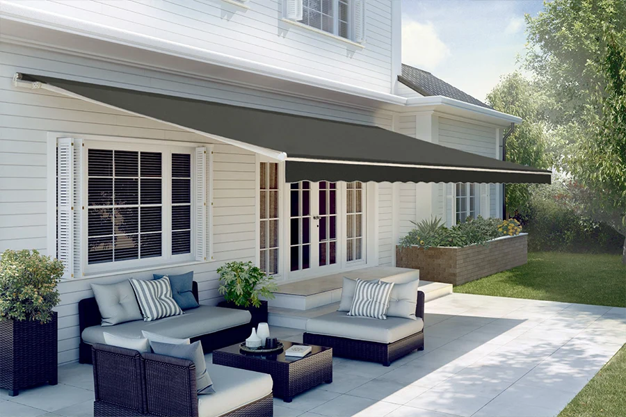 You'll only get the best retractable awning from an expert installer. A dark gray retractable awning shading a white stone patio