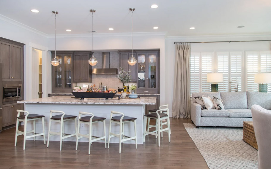 Illuminate your home with custom interior shutters in Las Vegas. White arched shutters in a white kitchen with lots of light.
