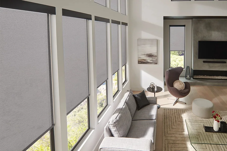 Grey solar shades on a row of five windows in a living room