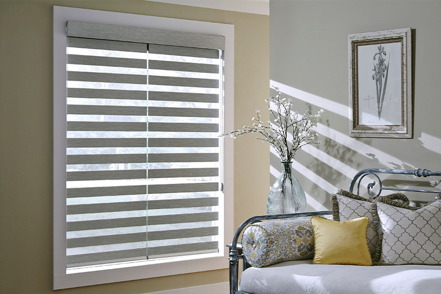 Find Practical and stylish window blinds for Las Vegas homes at Sunburst. Gray blinds on a large window next to a couch.
