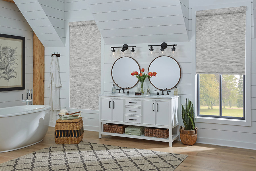 Slim-profile roller shades easily fit shallow windows in your Las Vegas home. Gray patterned roller shades on bathroom windows
