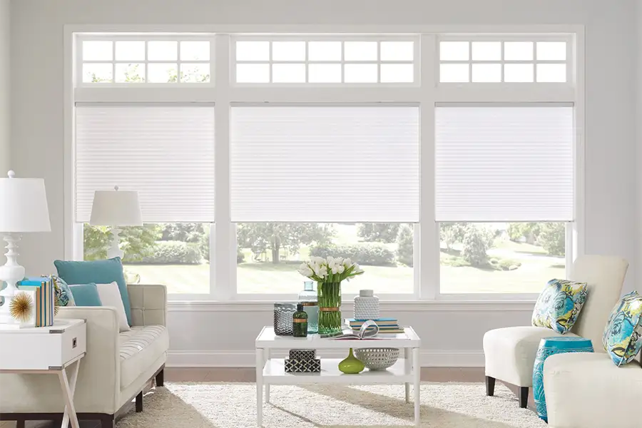 Insulating cellular shades can help keep cold air and hot UV rays from entering your Las Vegas home. White cellular shades on windows in a white living room